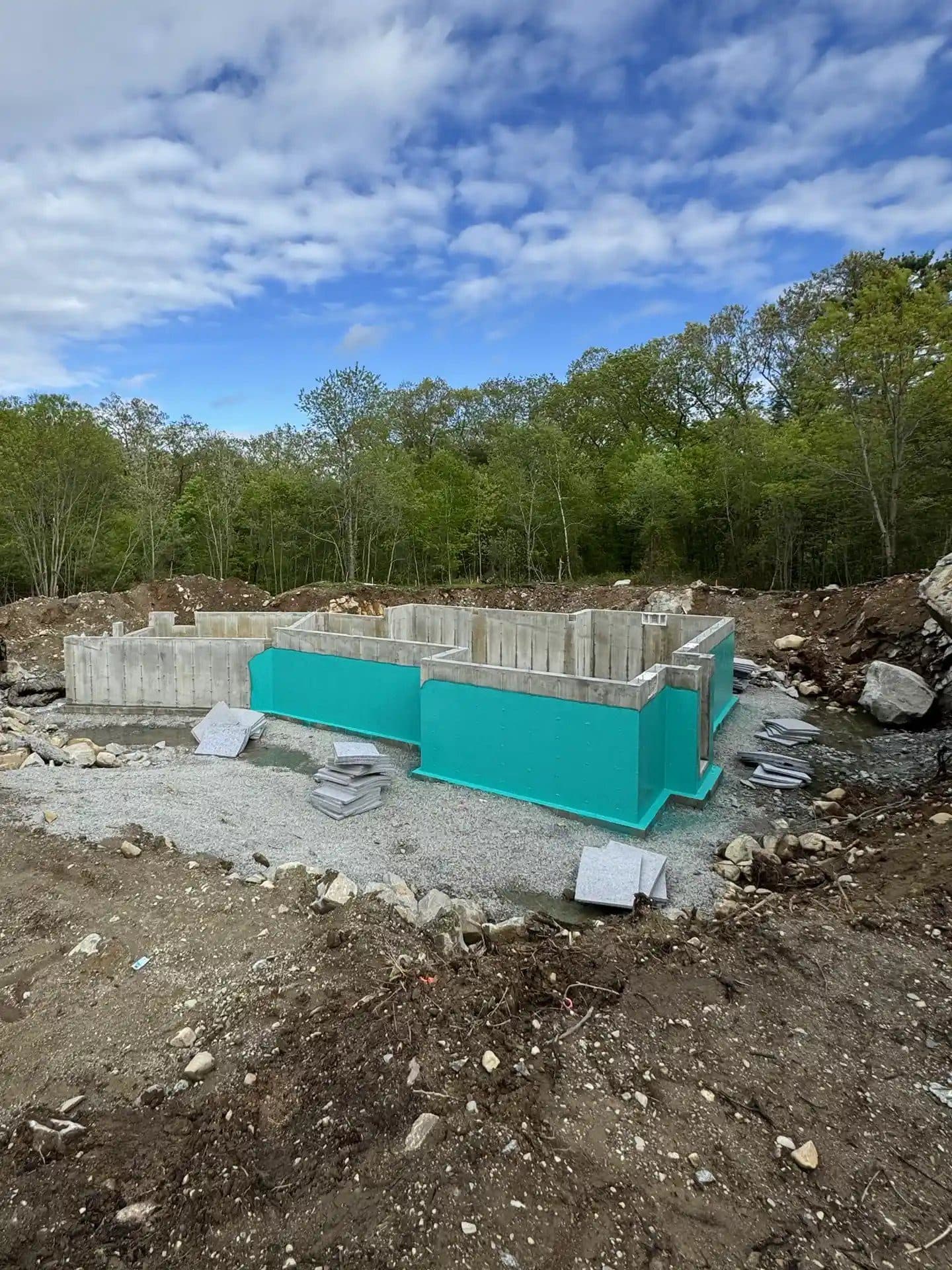 Full foundation with teal Rub-R-Wall coating and drainage boards on the ground