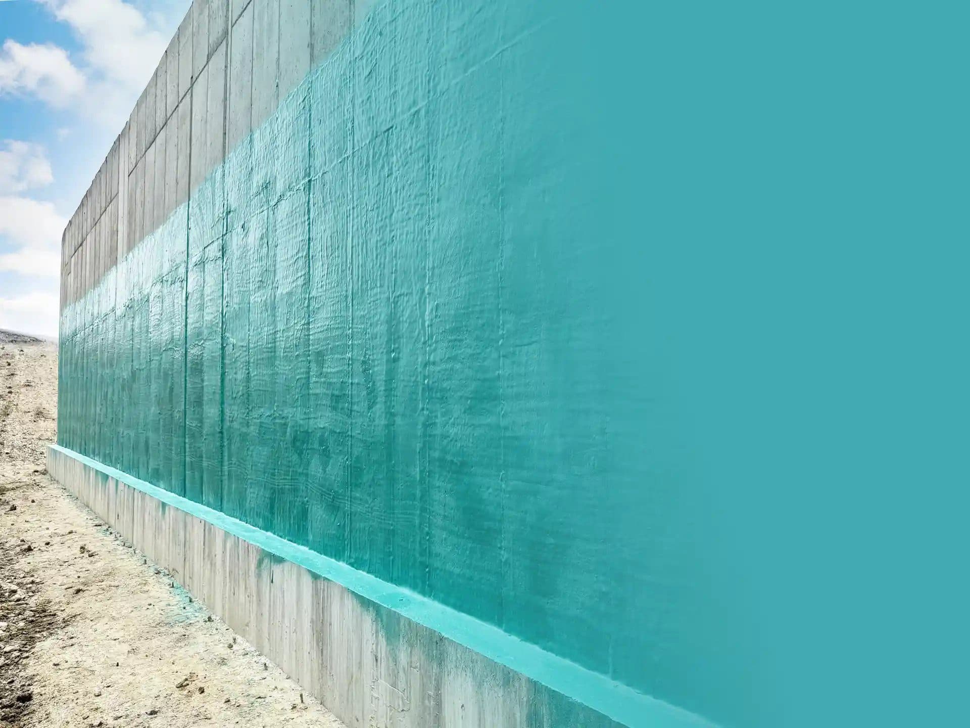 Rub-R-Wall on poured concrete — teal membrane on a receding foundation wall