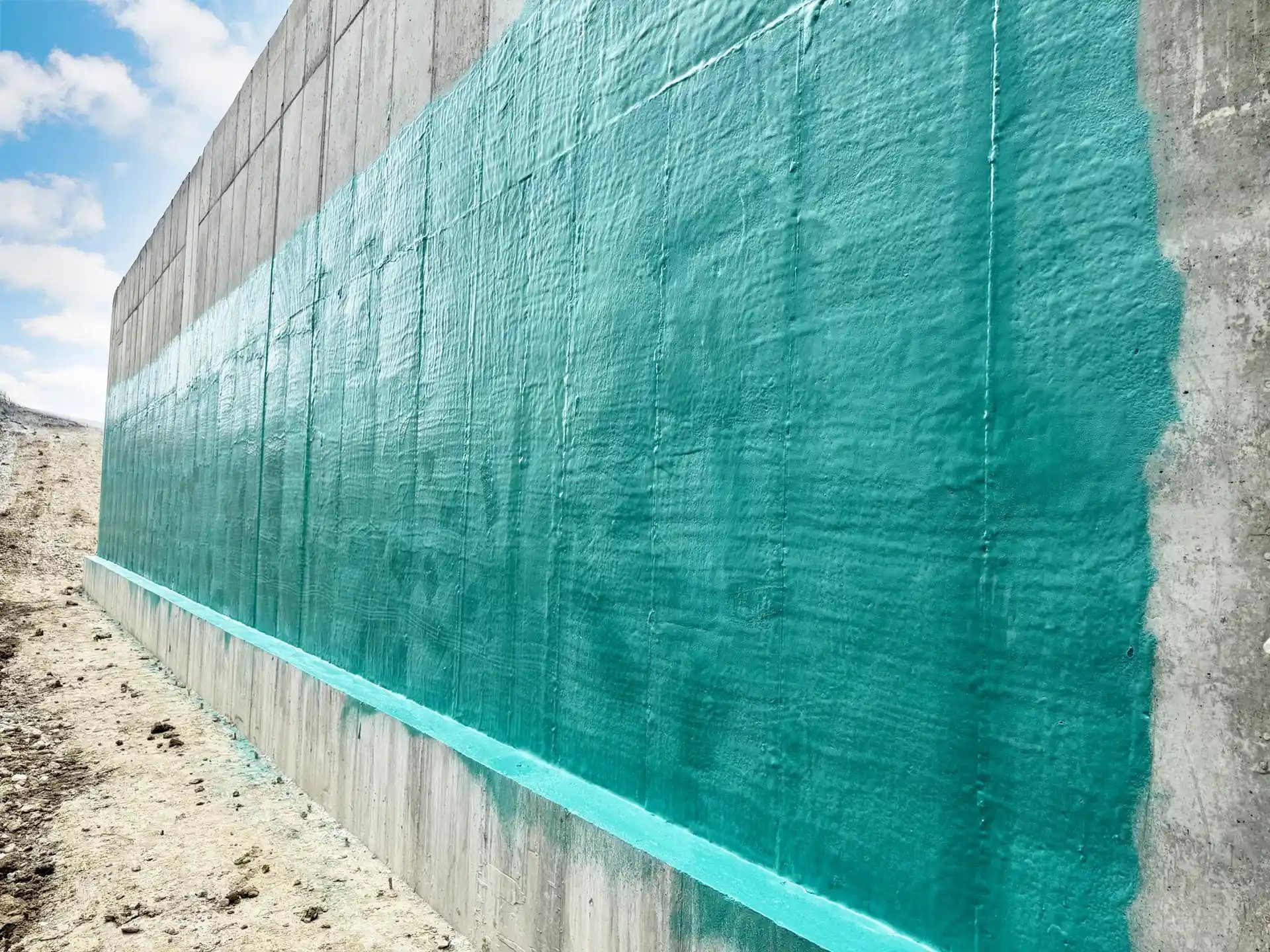 Finished teal Rub-R-Wall membrane on a poured concrete foundation wall